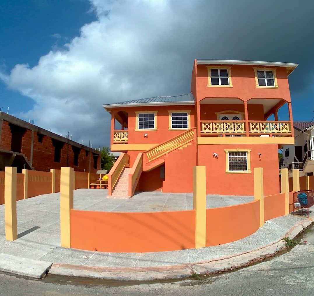 A large orange house with a staircase leading up to the second floor