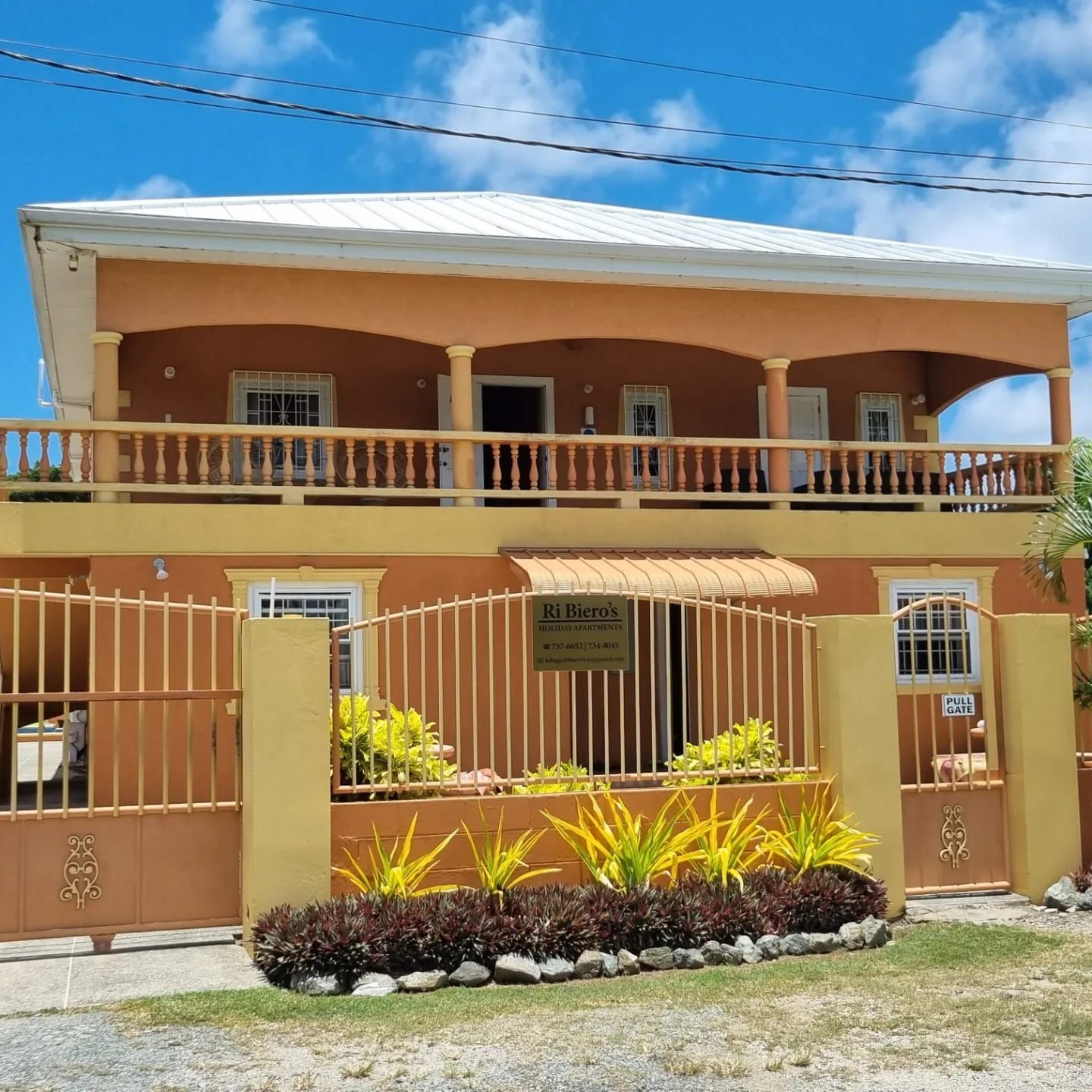 A large house with a fence around it and a balcony