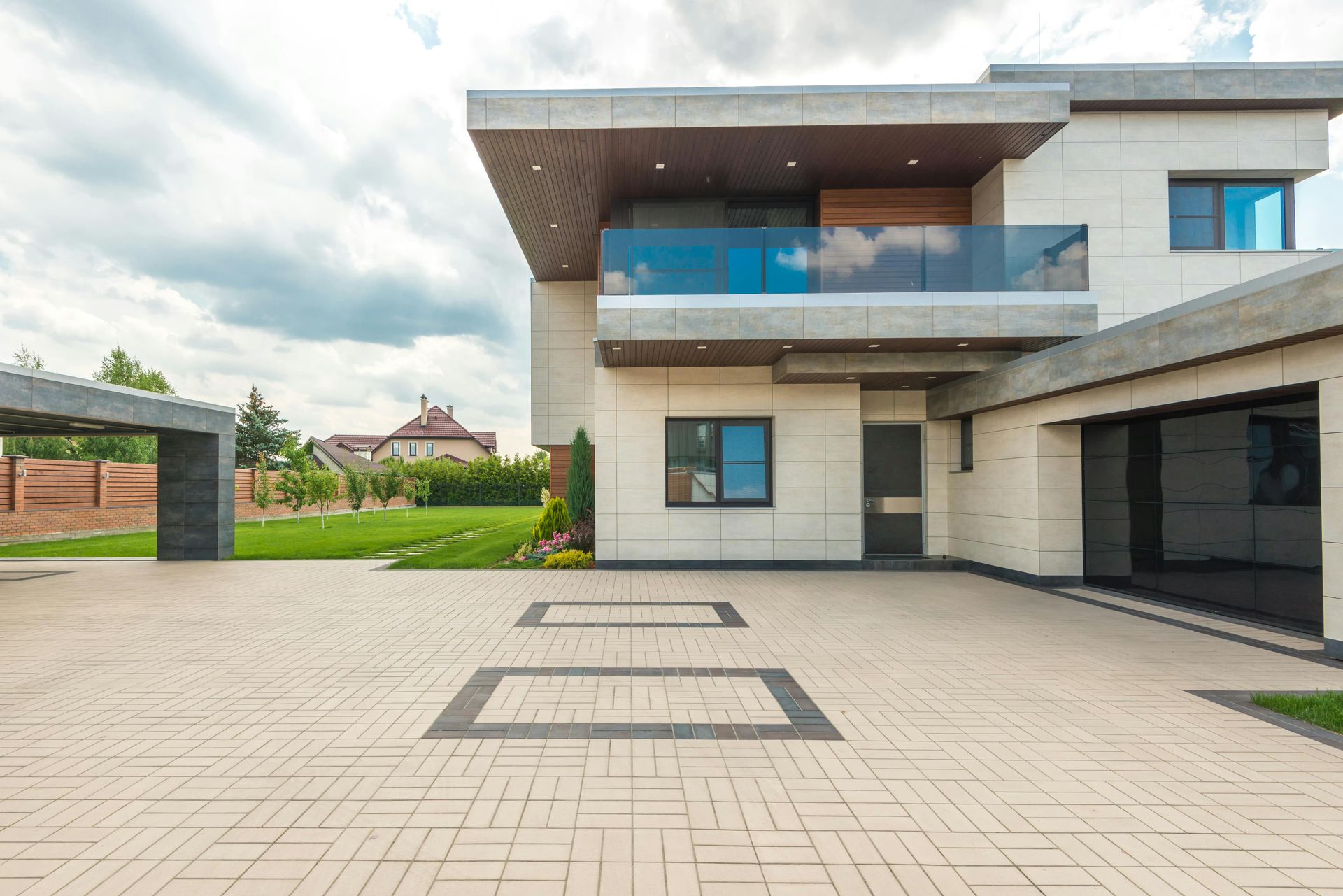 A large modern house with a large driveway in front of it.