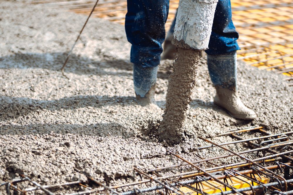 A person is pouring concrete on a construction site.