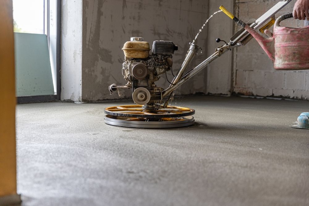 A person is using a machine to level a concrete floor.
