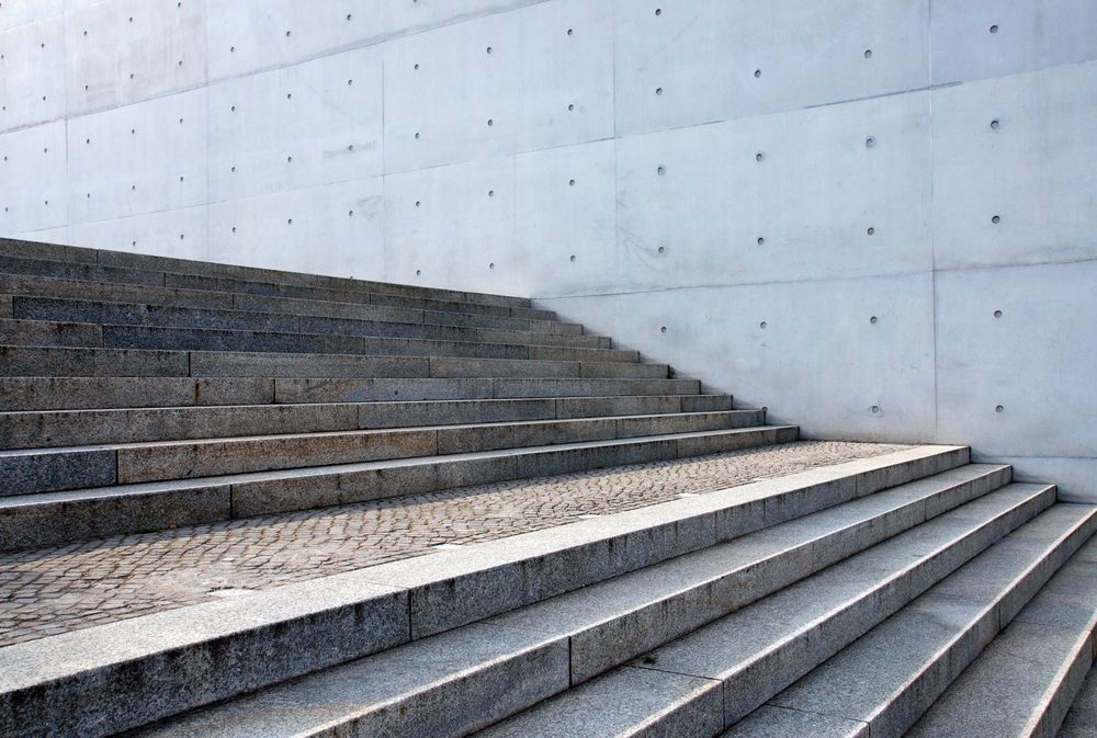 A set of stairs leading up to a concrete wall.