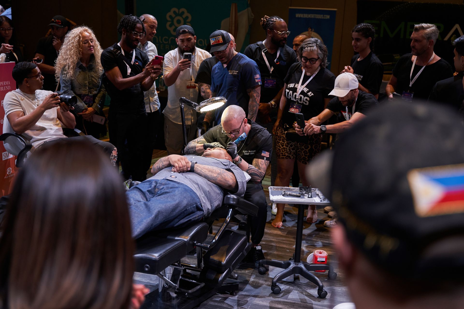 An SMP INK CDA Student Practitioner drawing the reference line on the scalp of  an SMP client in a class setting.