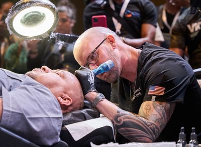 An SMP INK CDA Student Practitioner drawing the reference line on the scalp of  an SMP client in a class setting.