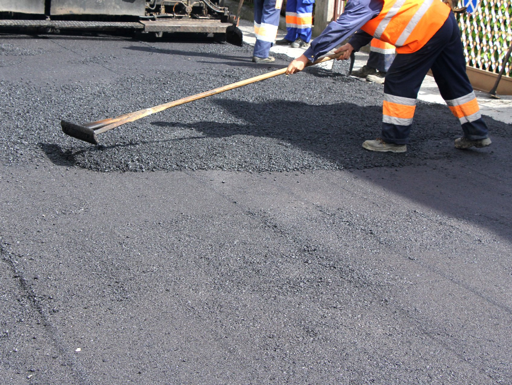 asphalt worker spreading asphalt for a patch repair in Las Cruces, NM