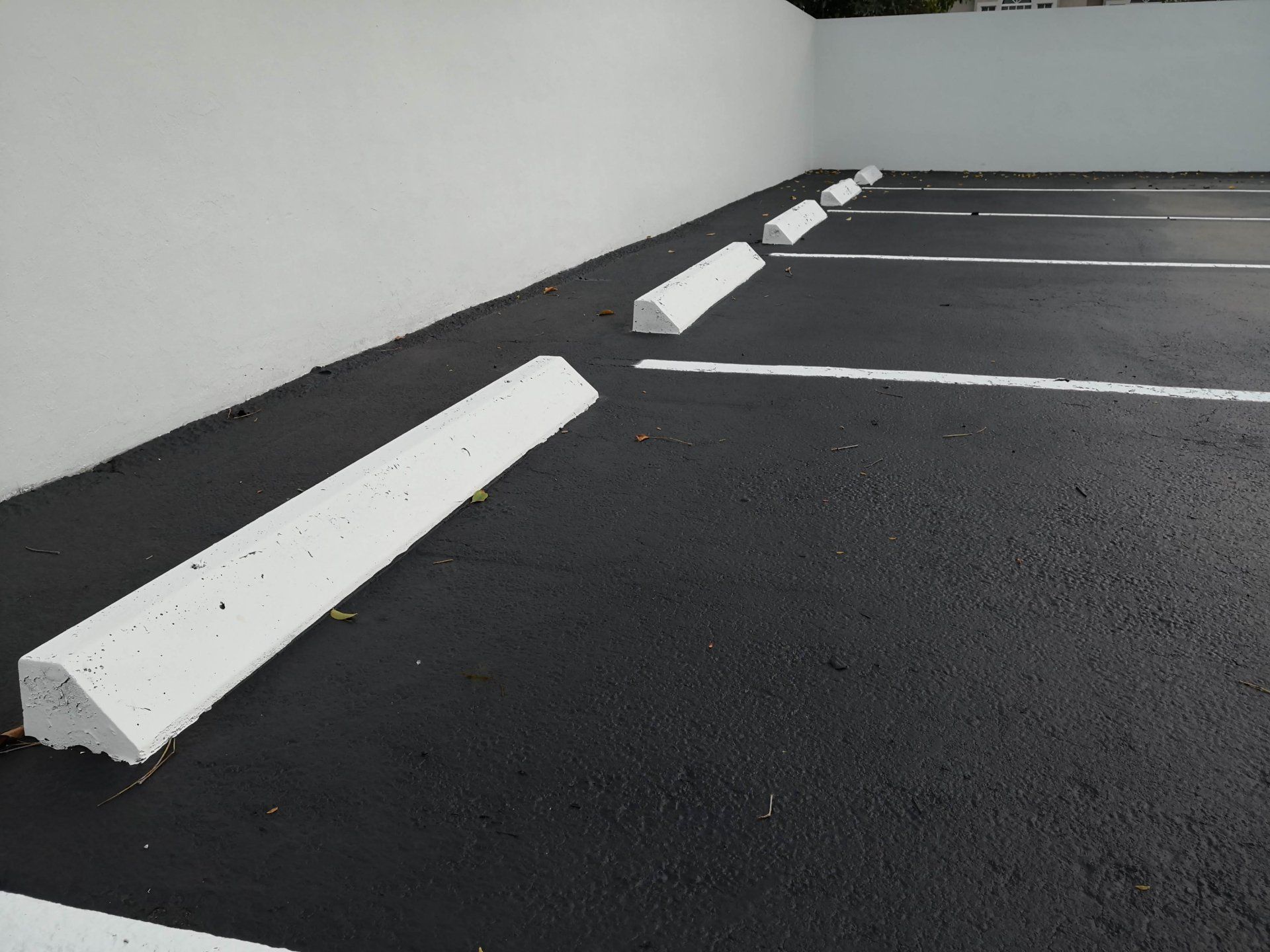 A fresh layer of sealcoat is applied to the parking lot to prolong its durability.