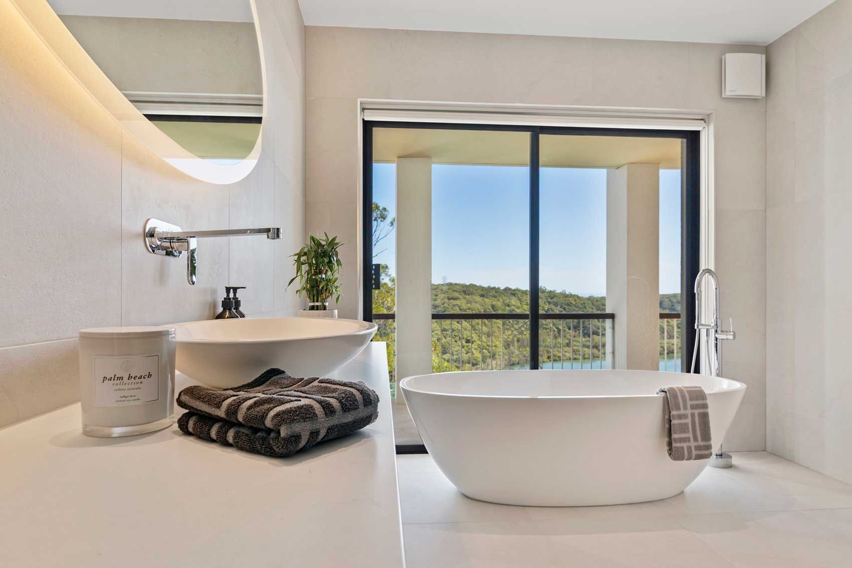 Luxury bathroom renovation featuring a stone vanity, soaking tub with a view, and high-end chrome fixtures in a bright, open space.