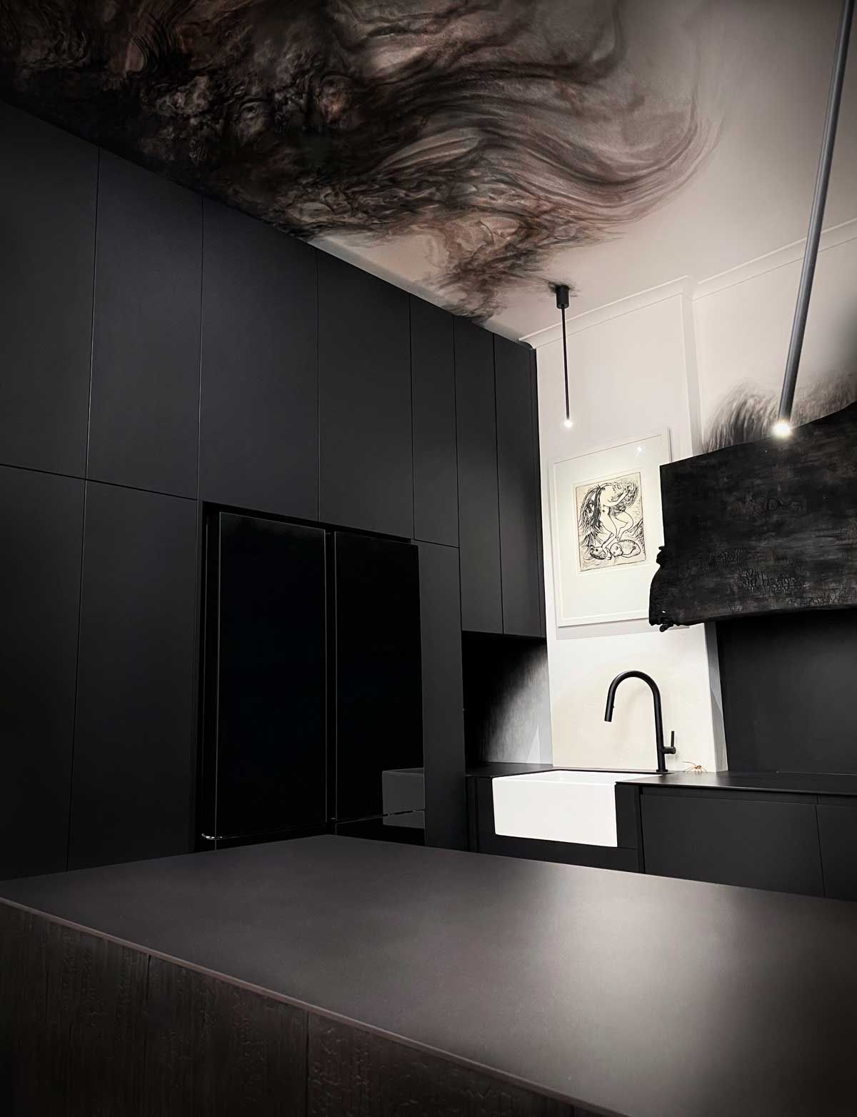 Ultra-modern kitchen renovation with matte black cabinetry, a white apron-front farmhouse sink, black tapware, and a marble-swirl ceiling mural.