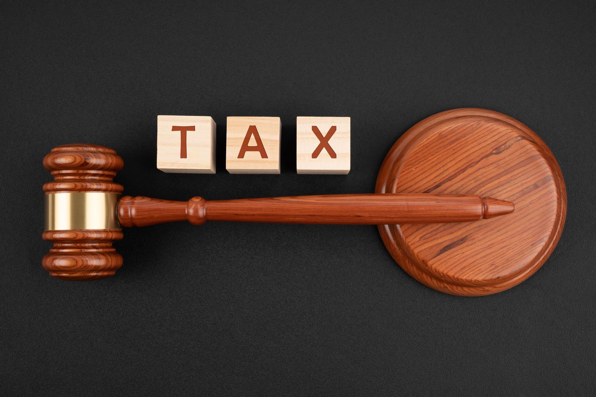 Judge gavel and TAX wooden cube on a black leather, Flat lay | Taxpayers Guardian | Alexandria, VA