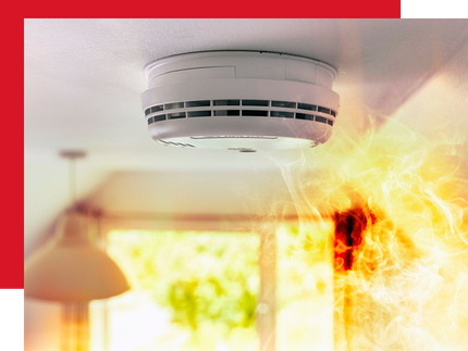 A wooden boardroom table with chairs and pens laid out on placemats, with a blurred office background.