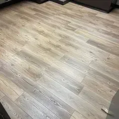 Wooden floor planks in varying shades of light brown and gray, installed diagonally.