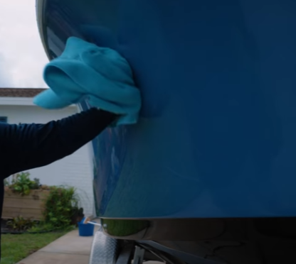 Drying dark blue boat with light blue chamois towel