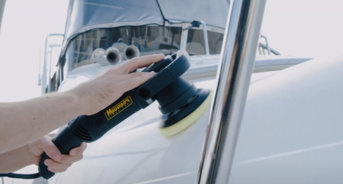 Machine buffing white sport fishing boat.