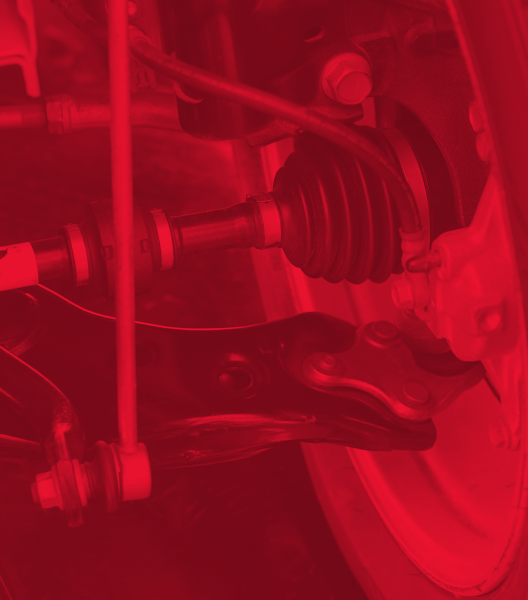 Red-tinted close-up of a vehicle's suspension system, showing components like a driveshaft, stabilizer bar, and wheel.