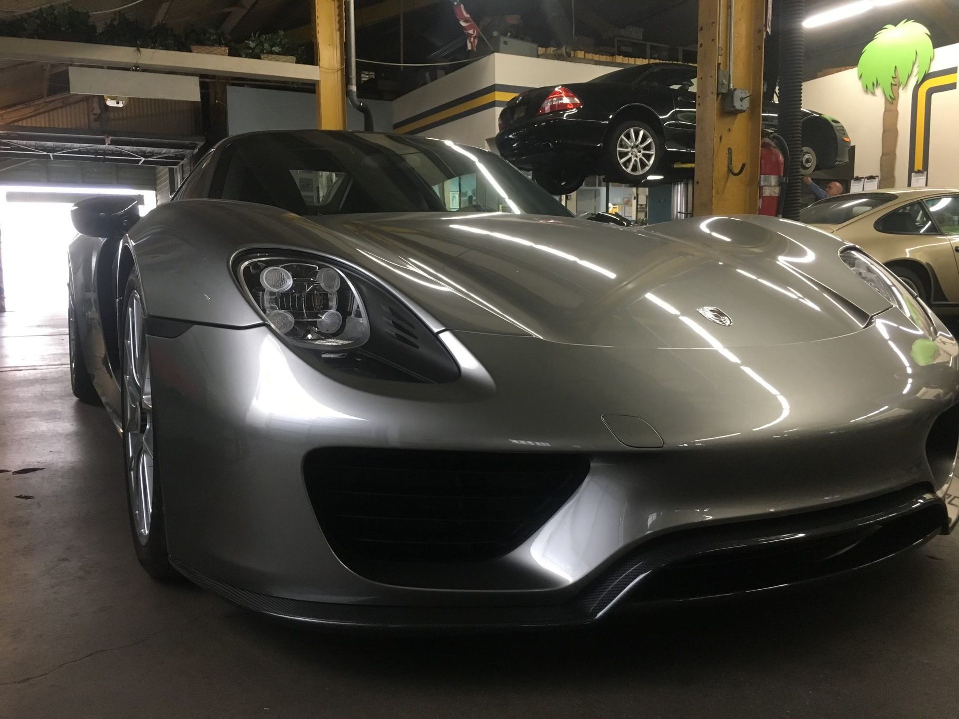 Silver Porsche 918 Spyder in a garage.