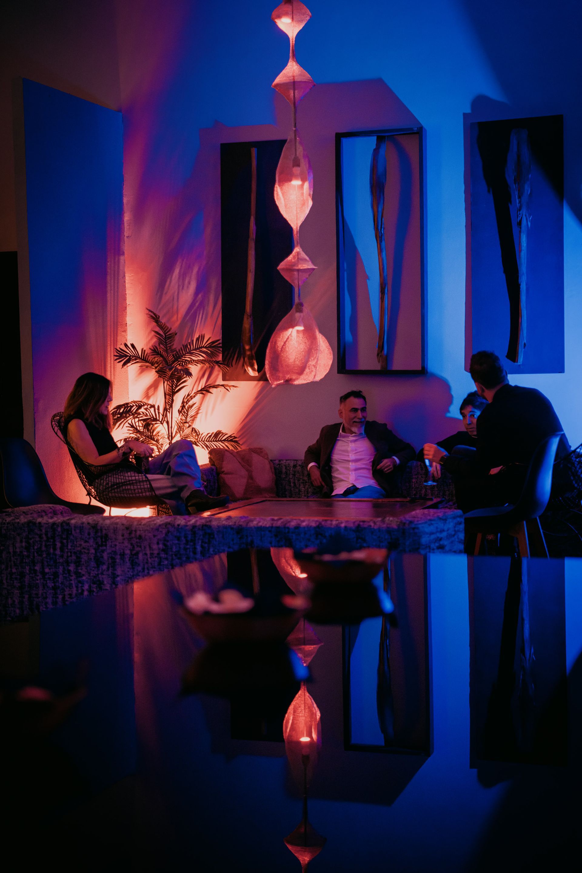Un loft spazioso e luminoso con tavolo da pranzo, zone salotto, lampade a sospensione e grandi finestre.
