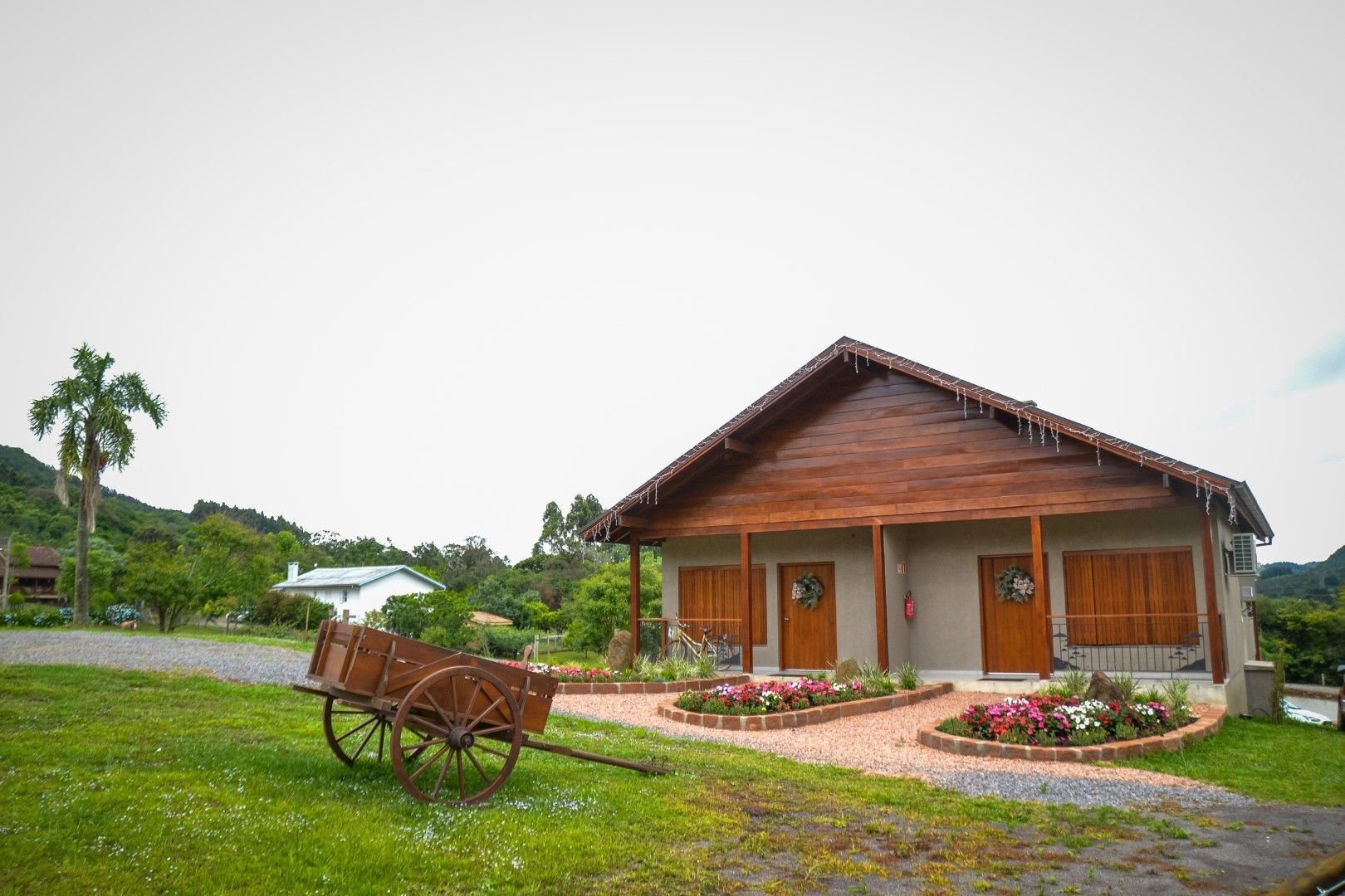 Uma casa de madeira com uma carruagem puxada por cavalos na frente.