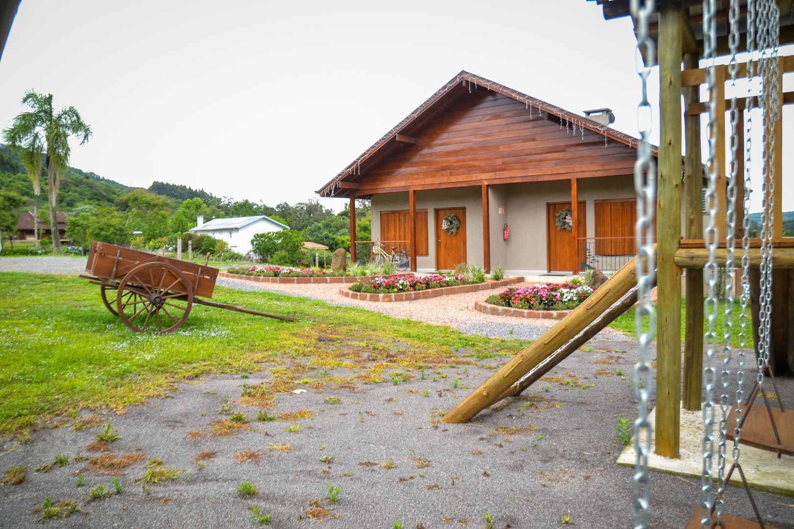 Uma casa de madeira com um carrinho de mão na frente.
