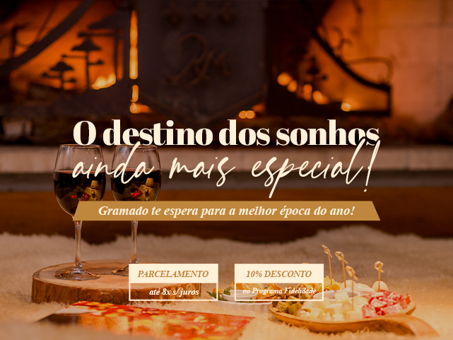 Algumas taças de vinho sobre uma mesa de madeira ao lado de uma pizza.