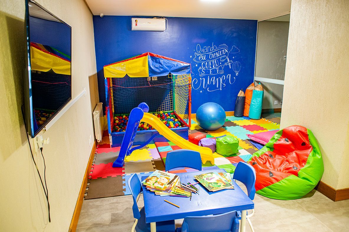 Um quarto infantil com mesa, cadeiras e um escorregador.