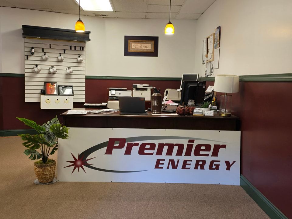 Two people standing in front of a premier energy co sign