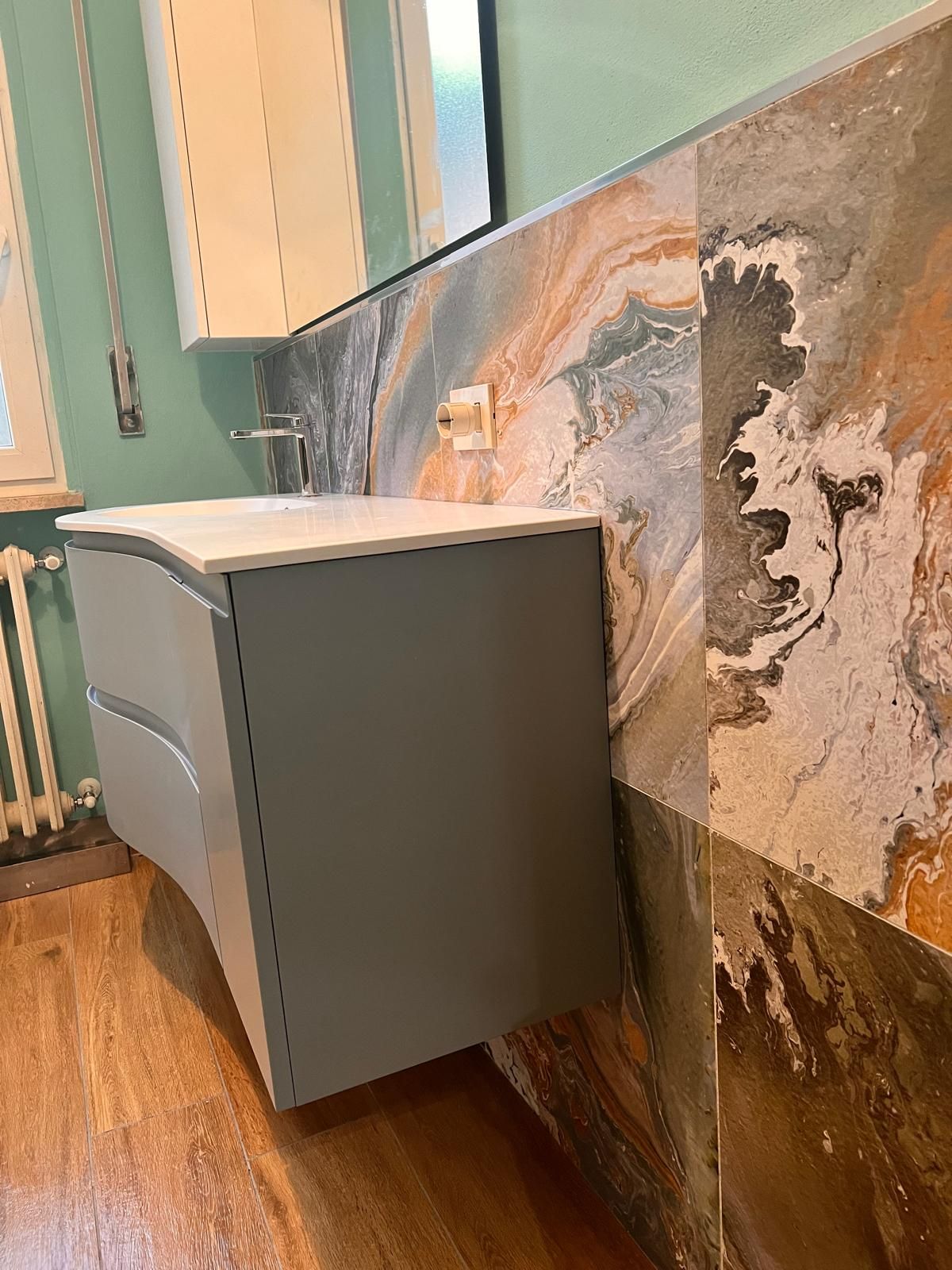 Cucina moderna con mobili bianchi, ripiani scuri, pensili in legno e un bancone per la colazione con sgabelli.