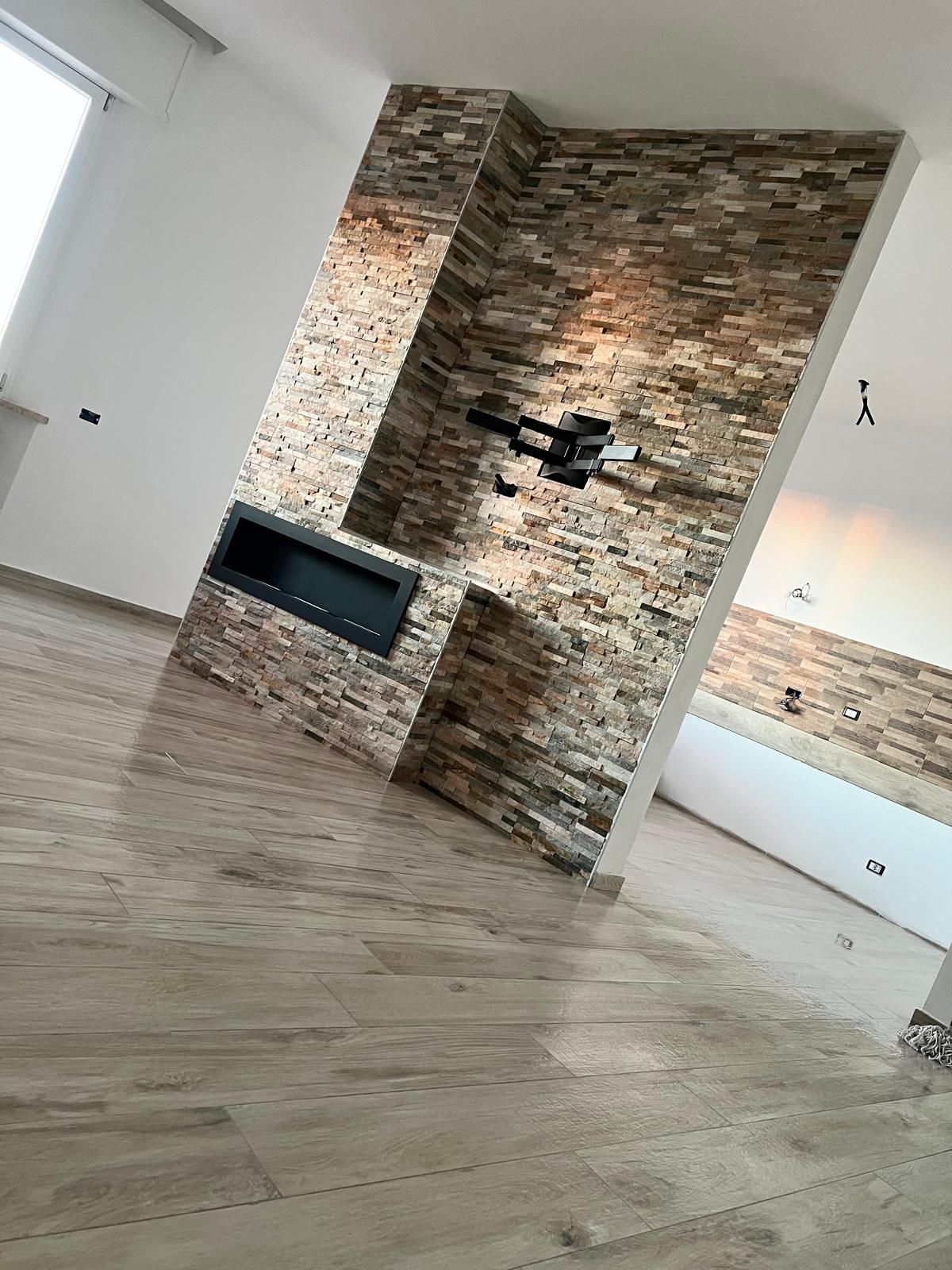 Ristrutturazione della cucina: pareti bianche, piastrelle a fantasia, teli di plastica blu e detriti sul pavimento.