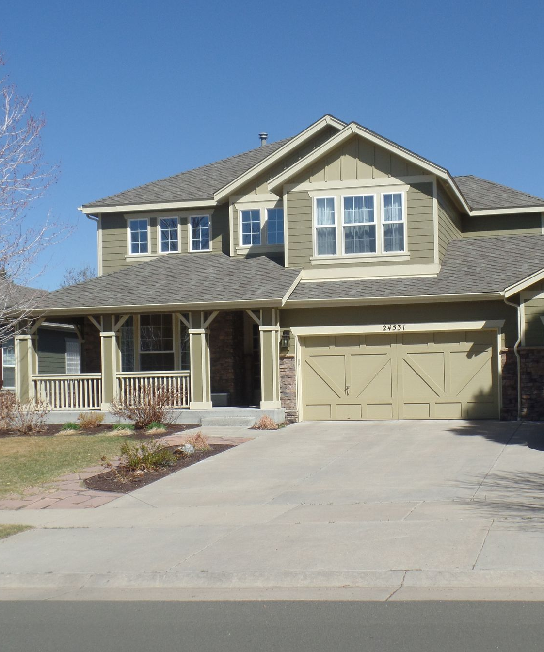 Blue house with red door, brick accents, and a gray SUV parked in the driveway.