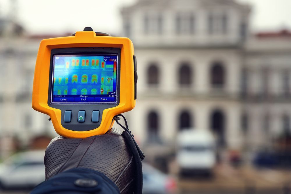 Hand Holding Yellow Thermal Imaging — Scott MacTaggart Building & Pest Inspections In Tuncurry, NSW
