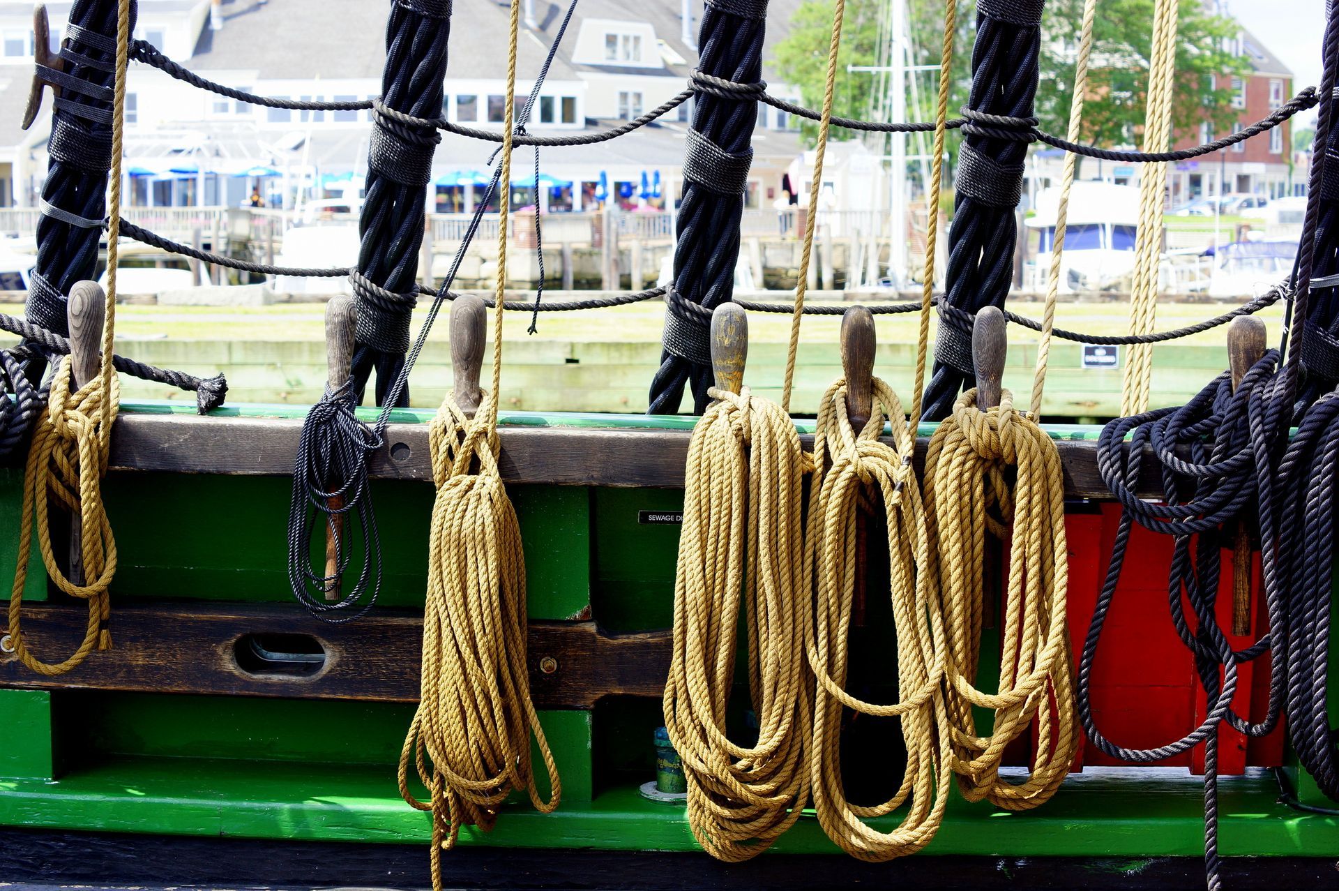 A partial view of a green vessel side with a variety of ropes.