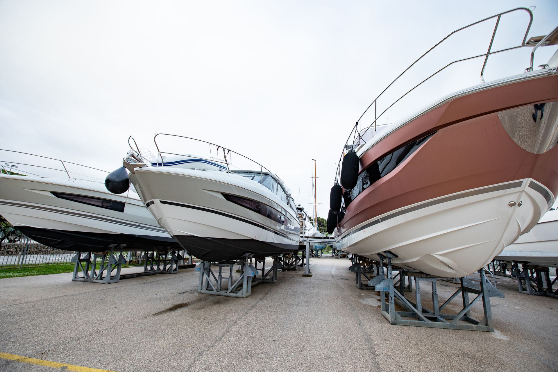 Boats resting on dry land, prepped with gear and accessories, ready for summer launch.