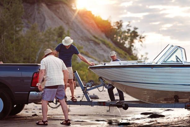 A group of men are loading a boat onto a trailer.