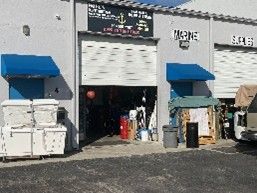 Exterior of open garage bays with equipment and gear visible inside.