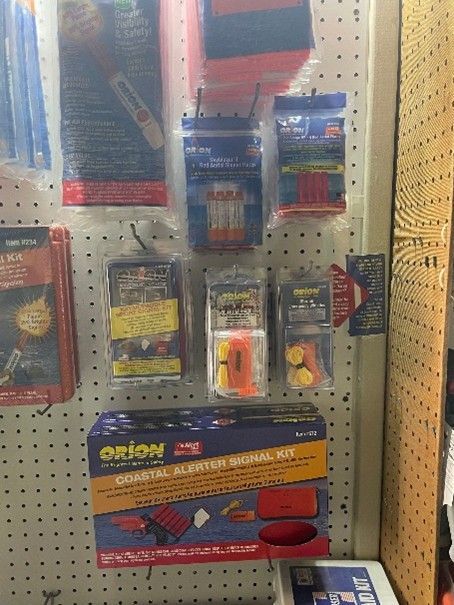 Display of Orion marine signal kits and safety gear on a pegboard wall.