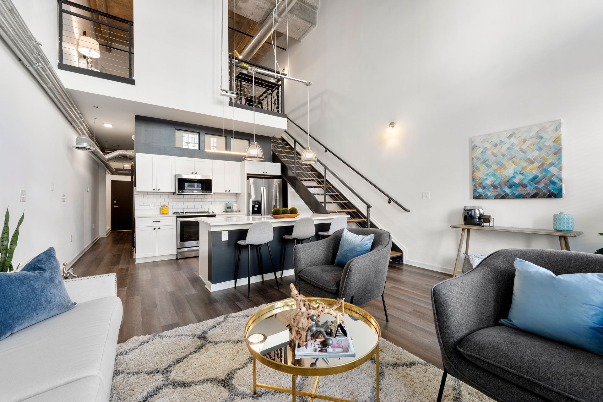 A living room with a couch , chairs , and a coffee table.
