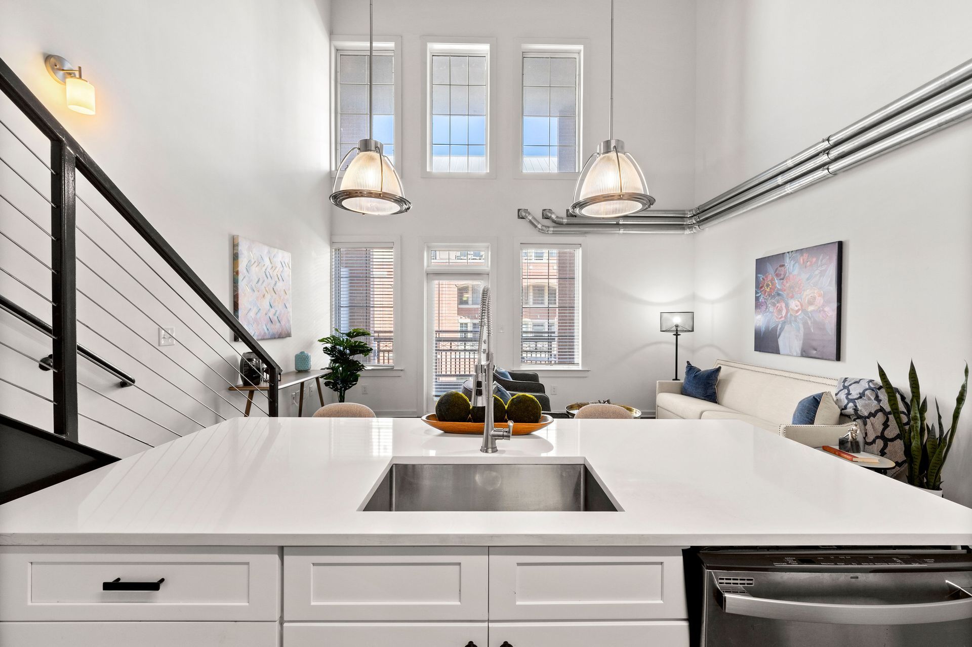 A kitchen with a sink and a living room in the background.
