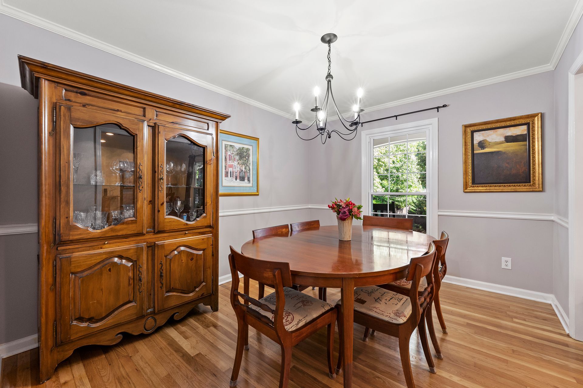 A dining room with a table and chairs and a hutch.