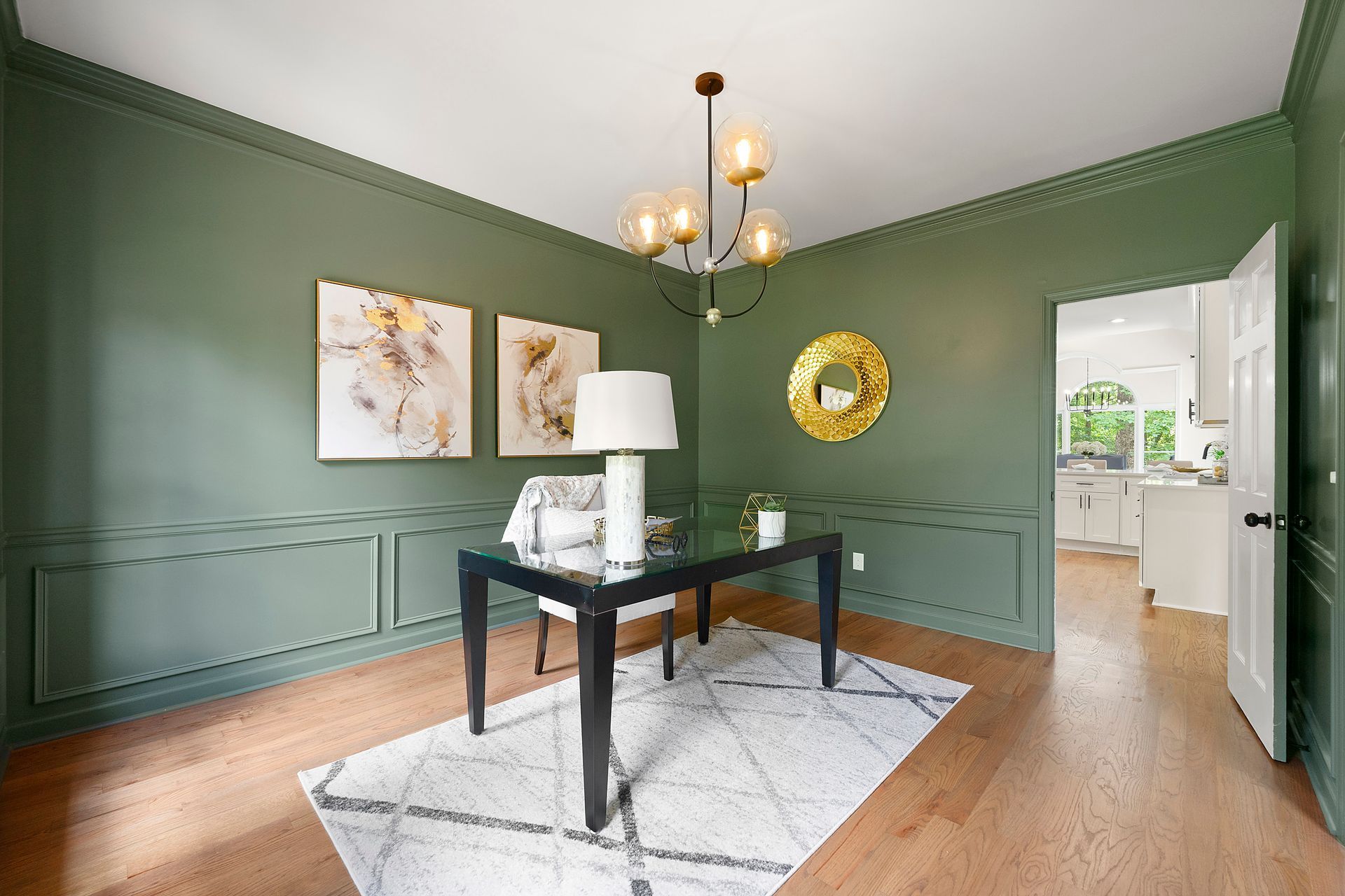 A home office with green walls and a desk and chair.