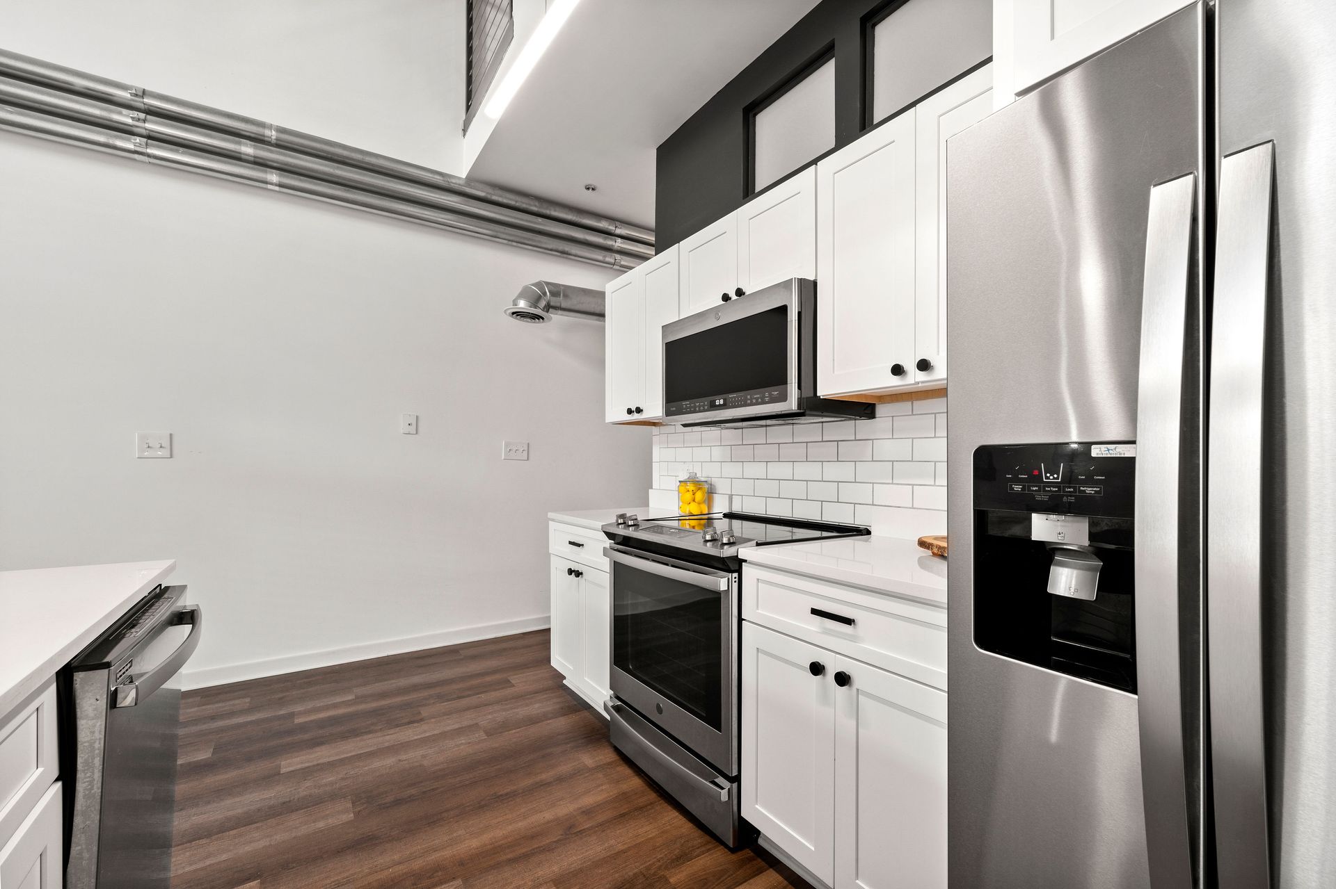 A kitchen with stainless steel appliances and white cabinets.