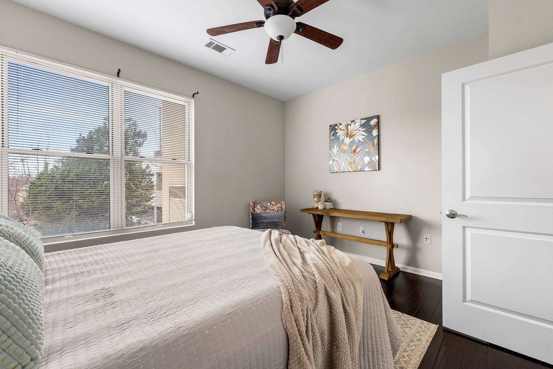 A bedroom with a bed and a ceiling fan