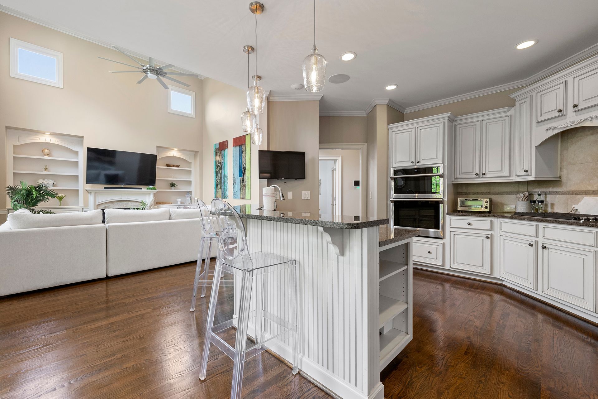 A kitchen with white cabinets and a large island in the middle of the room.