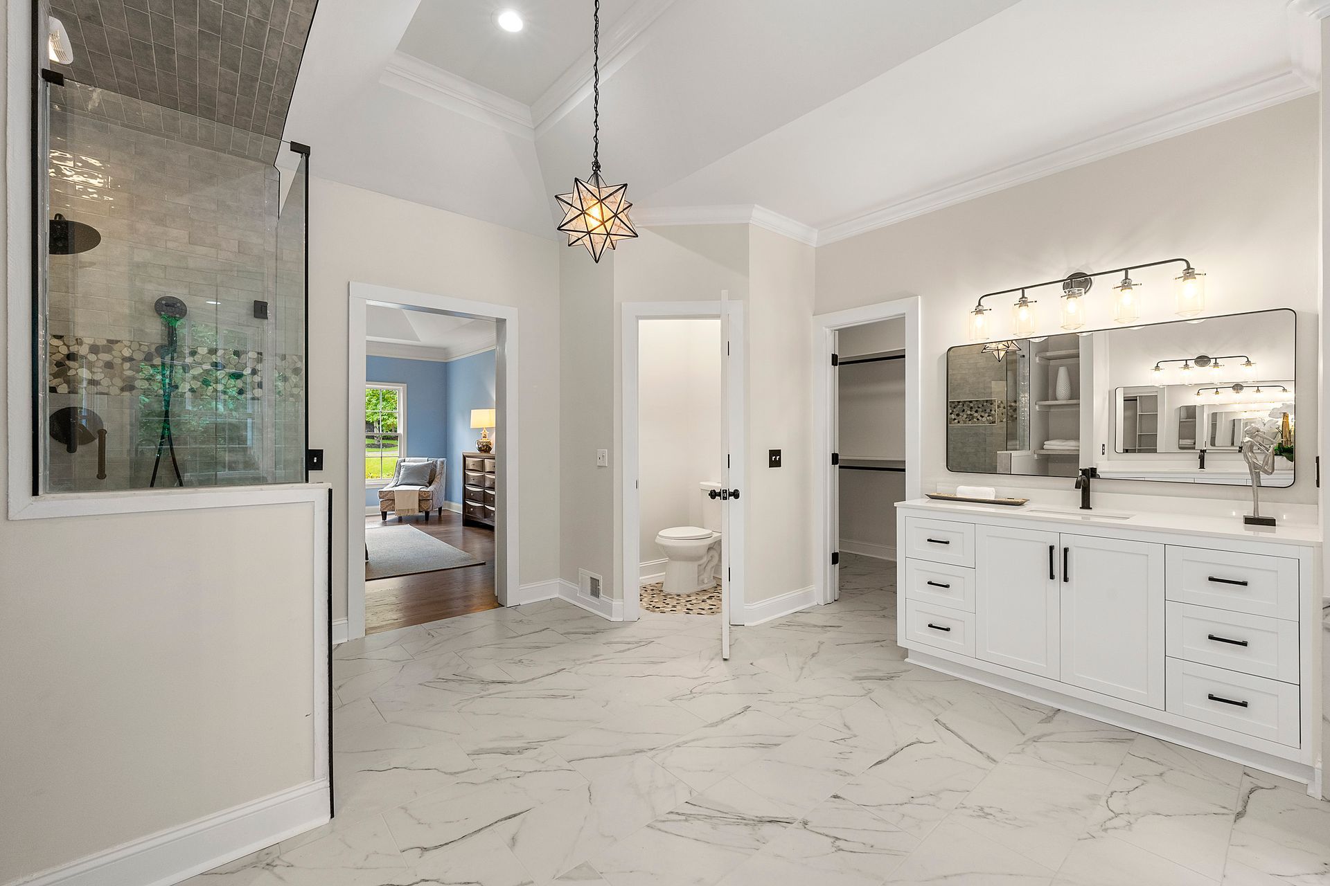 A bathroom with two sinks , a toilet , and a walk in shower.