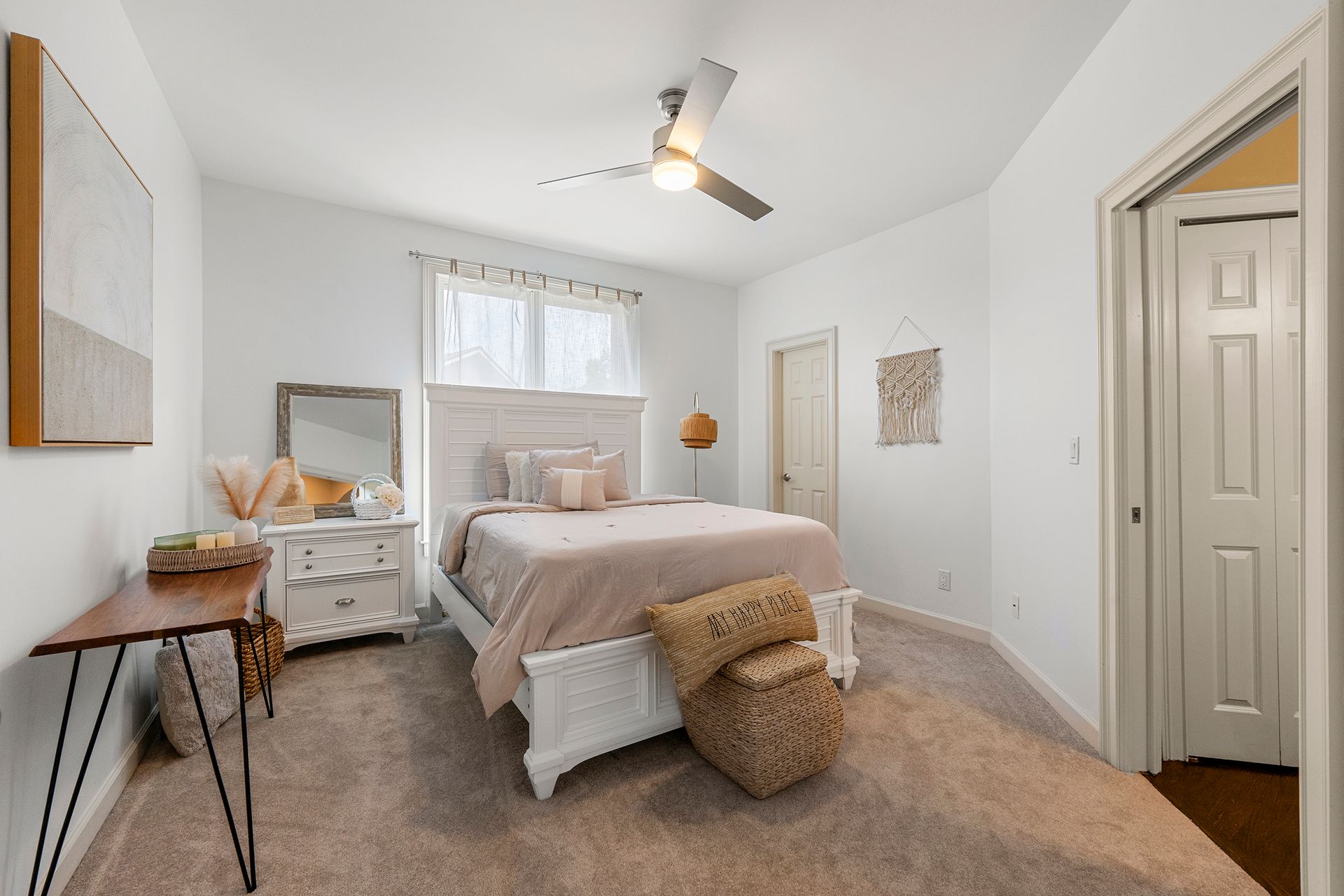 A bedroom with a bed , dresser , mirror and ceiling fan.