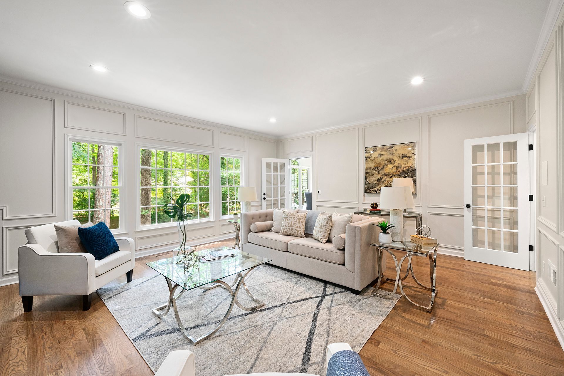 A living room with a couch , chairs , and a coffee table.