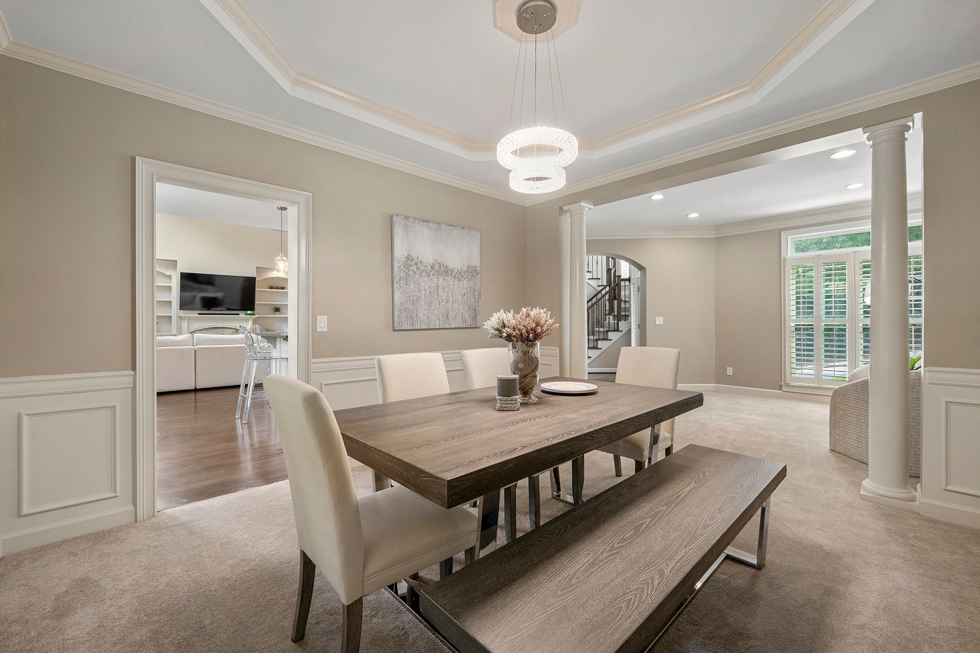 A dining room with a table and chairs and a bench.