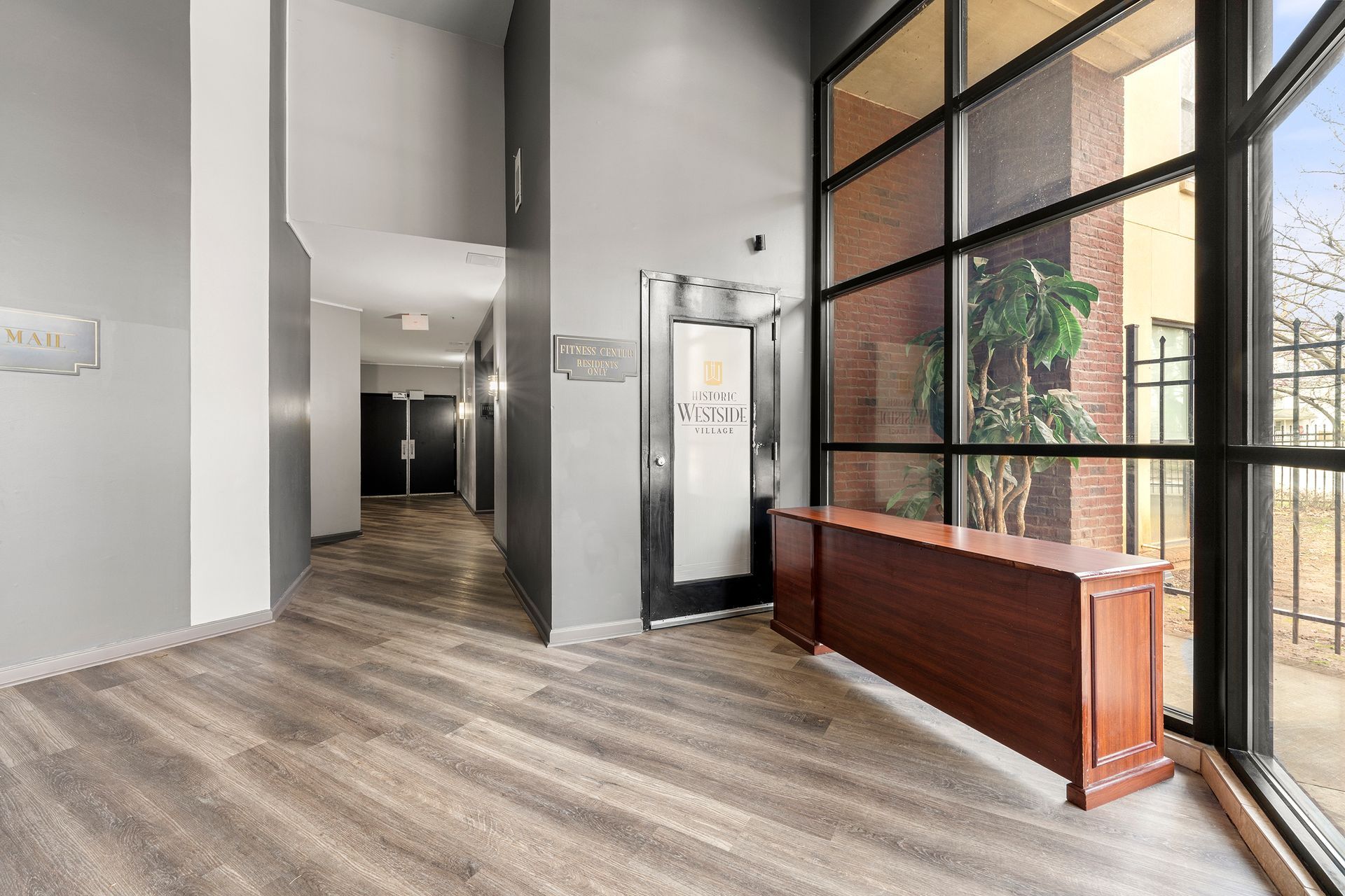 An empty lobby with a wooden table and a large window.
