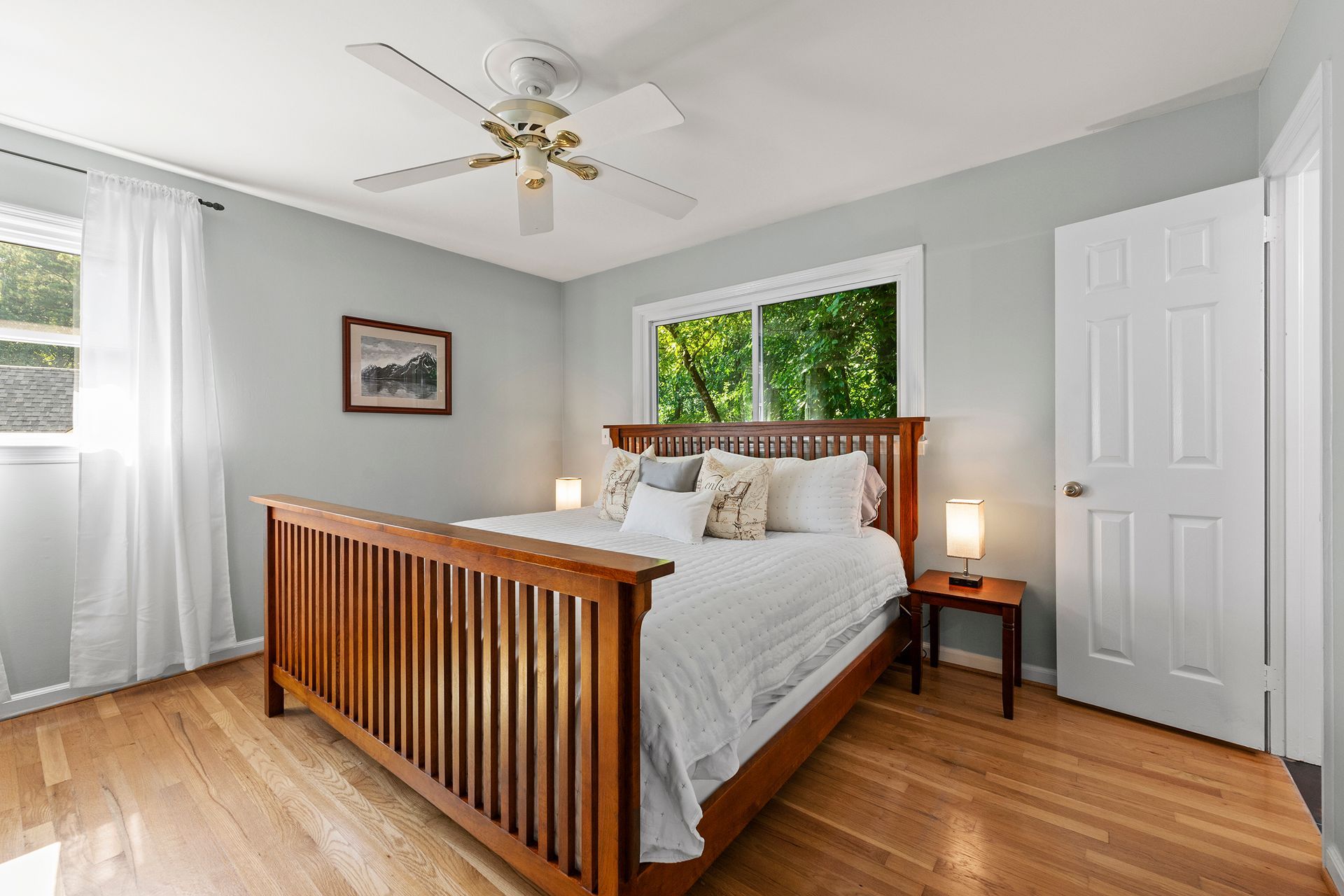 A bedroom with a wooden bed and a ceiling fan.