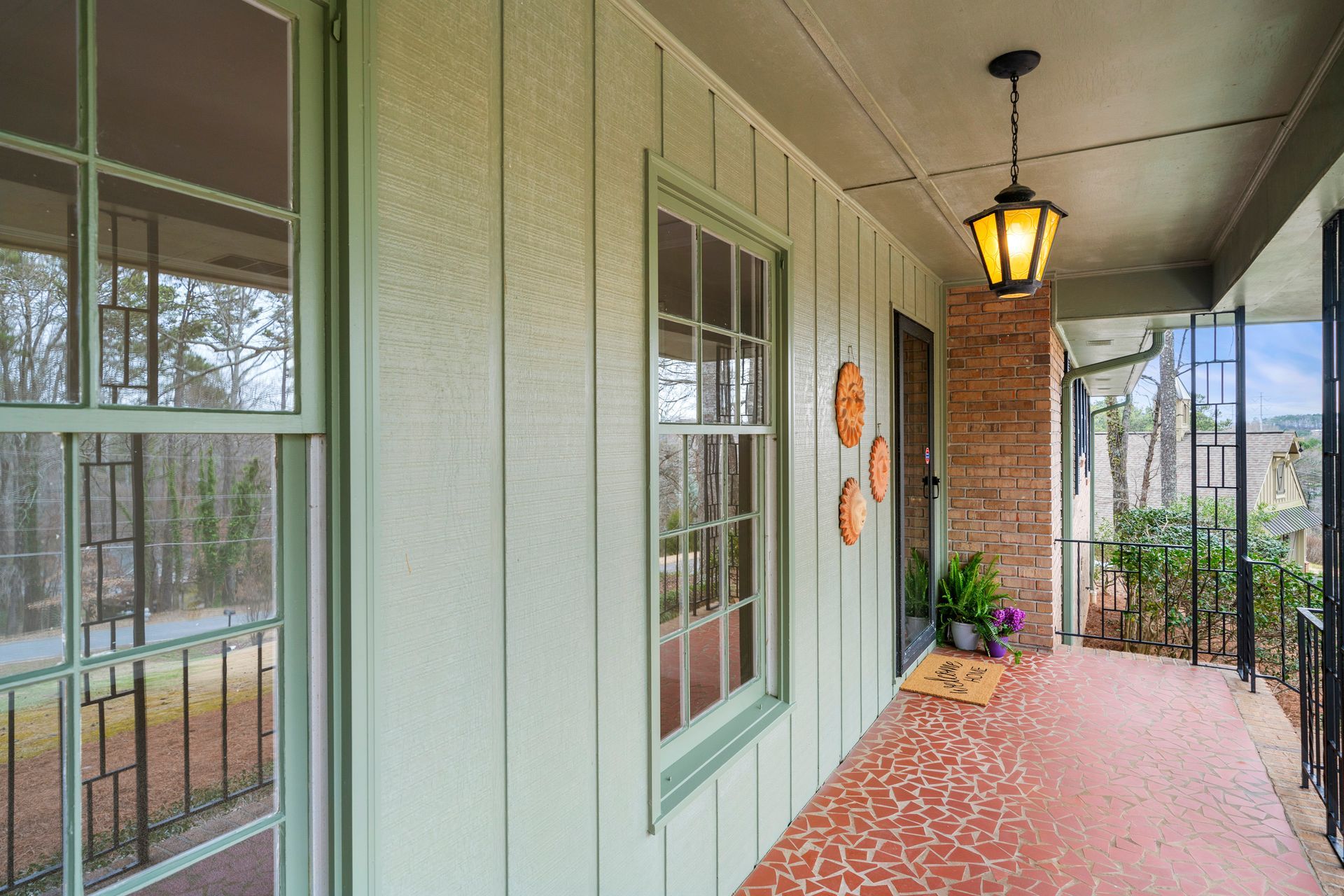 There is a porch with a lantern hanging from the ceiling.
