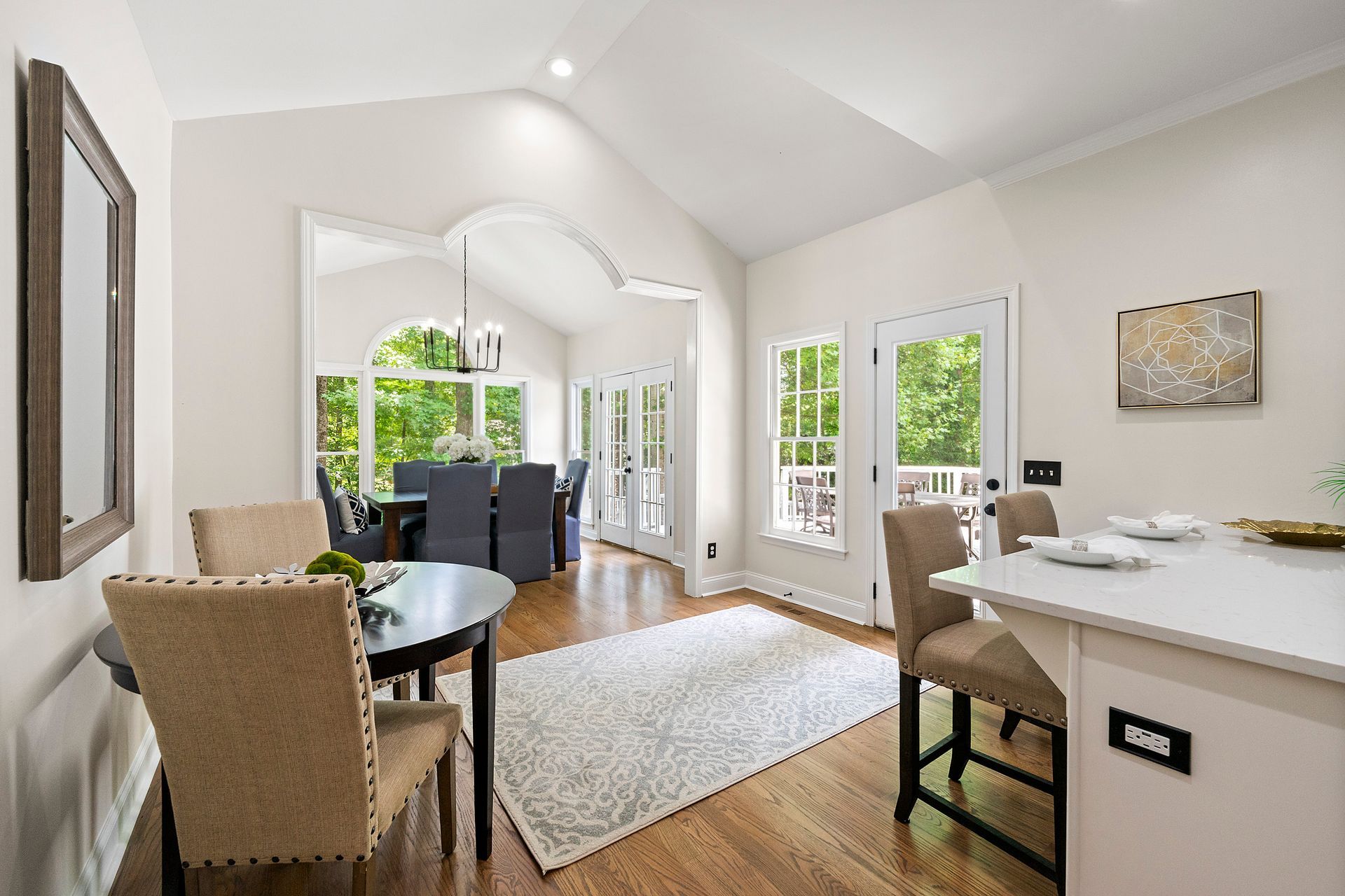 A dining room with a table and chairs and a large window.