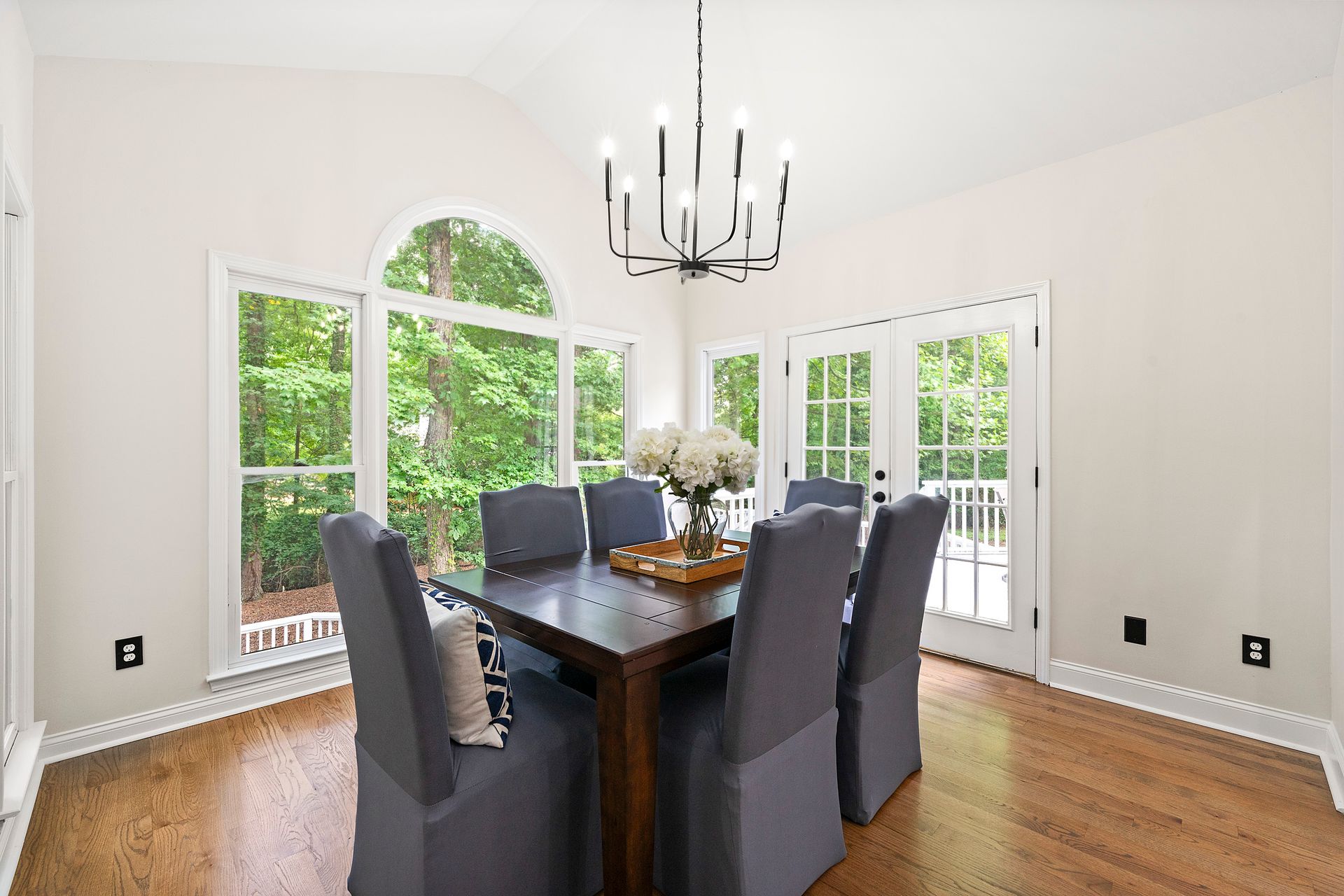 A dining room with a table and chairs and a chandelier
